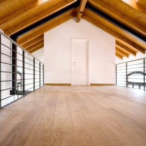 Soppalco mansardato in una grande casa con soffitto con travi a vista e architettura moderna