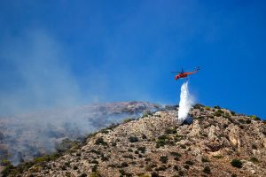 Un elicottero combatte contro le fiamme, durante gli incendi in Grecia