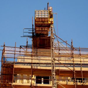 Vista dal basso del tetto di un edificio tutelato in fase di restauro con dei ponteggi