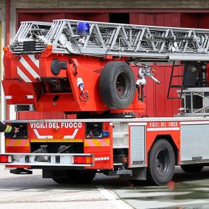 Un camion dei Vigili del Fuoco con due pompieri che stanno correndo durante un'esercitazione