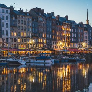 Vista notturna su un canale di Copenaghen, in Danimarca, con palazzi illuminati, acqua e imbarcazioni