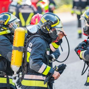 Dei Vigili del Fuoco italiani equipaggiati con casco e respiratore durante un'esercitazione