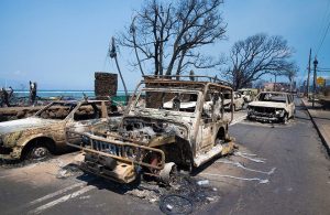 Dei mezzi bruciati su una strada di Lahaina, sull'isola di Maui, alle Hawaii, durante gli incendi dell'agosto 2023