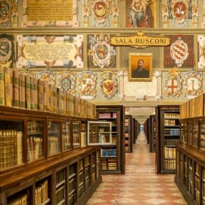 Una delle sale della storica Biblioteca dell'Archiginnasio di Bologna, con scaffali con libri antichi e pareti affrescate