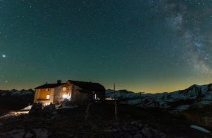 Un rifugio alpino illuminato in una notte stellata in montagna
