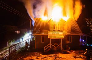 Una casa in legno sta bruciando dal tetto nella notte