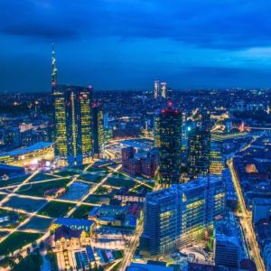 Vista dall'alto di Milano di notte, con i palazzi illuminati e i nuovi grattacieli