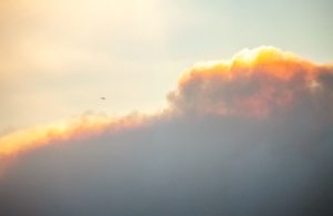 Un aereo vola attraverso il fumo e le nuvole causati dagli incendi boschivi a Los Angeles